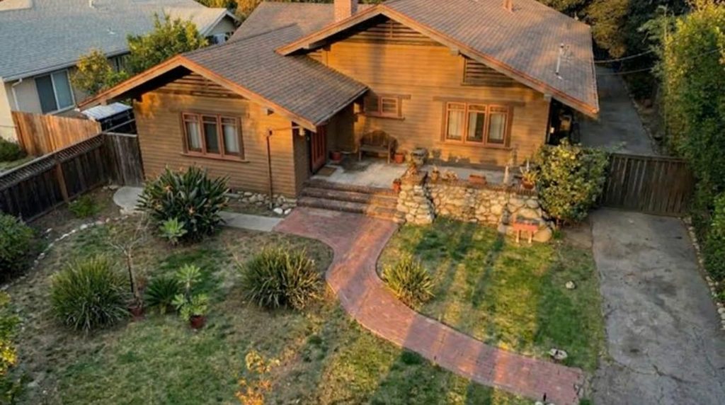 Aerial view of The Samuel Merrill House showing the double-gable roof, cobblestone terrace, and brick walkway