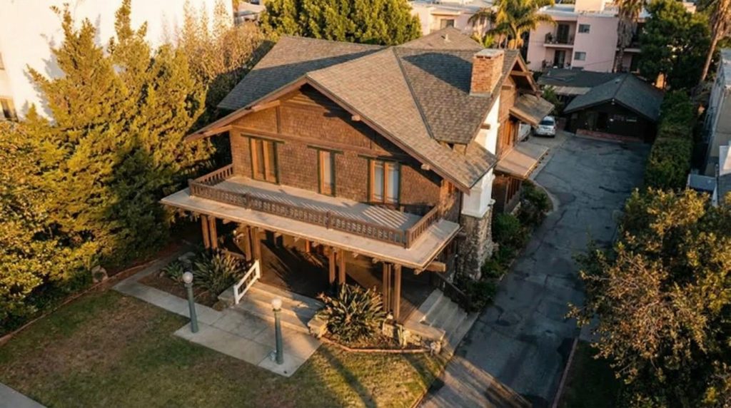 Aerial view of The Ernest W. Smith House showing the wraparound porch, shingled exterior, and driveway approach