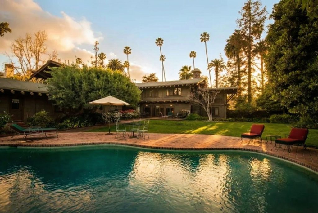 The Earle C. Anthony house backyard featuring a swimming pool surrounded by lush landscaping and garden walls