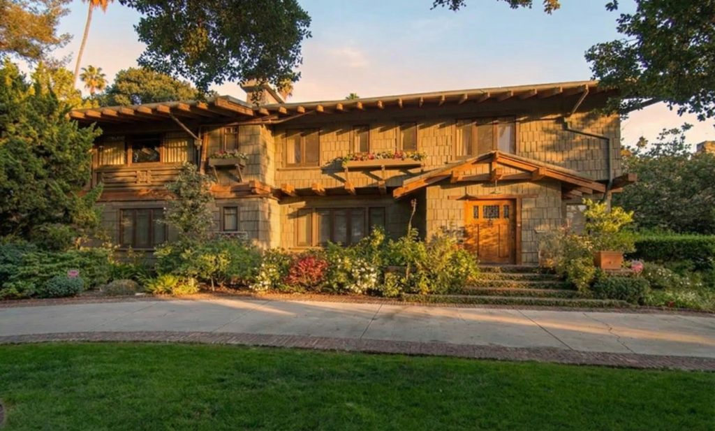 Front elevation of The Earle C. Anthony house showcasing its shingled facade, deep eaves, and protruding rafter tails