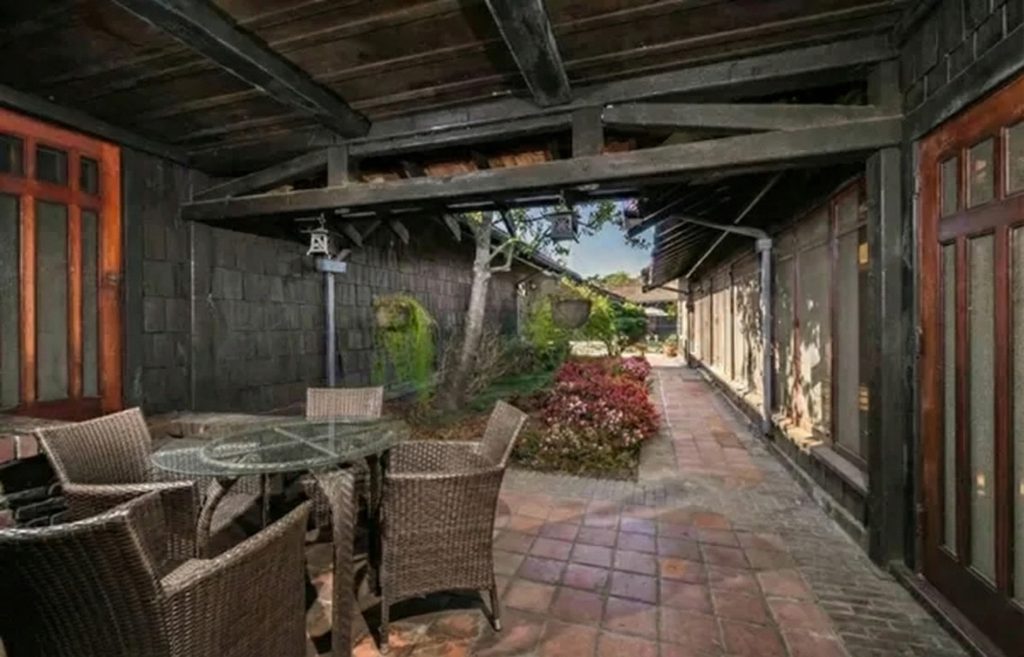 The rear terrace and courtyard of The Dr. S. S. Crow House, a private outdoor living space surrounded by the home's U-shaped wings and lush greenery.