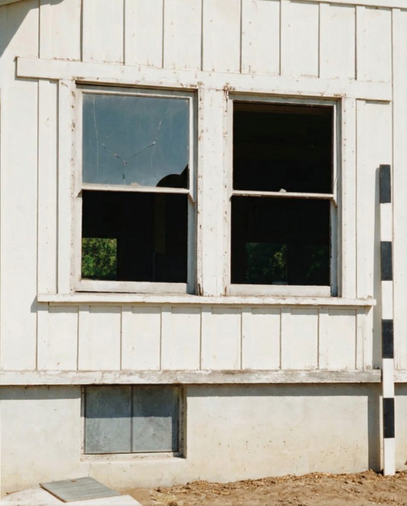 Close-up exterior detail of a window on The Sespe Ranch Bunkhouse showing the original wood-frame casement and siding texture