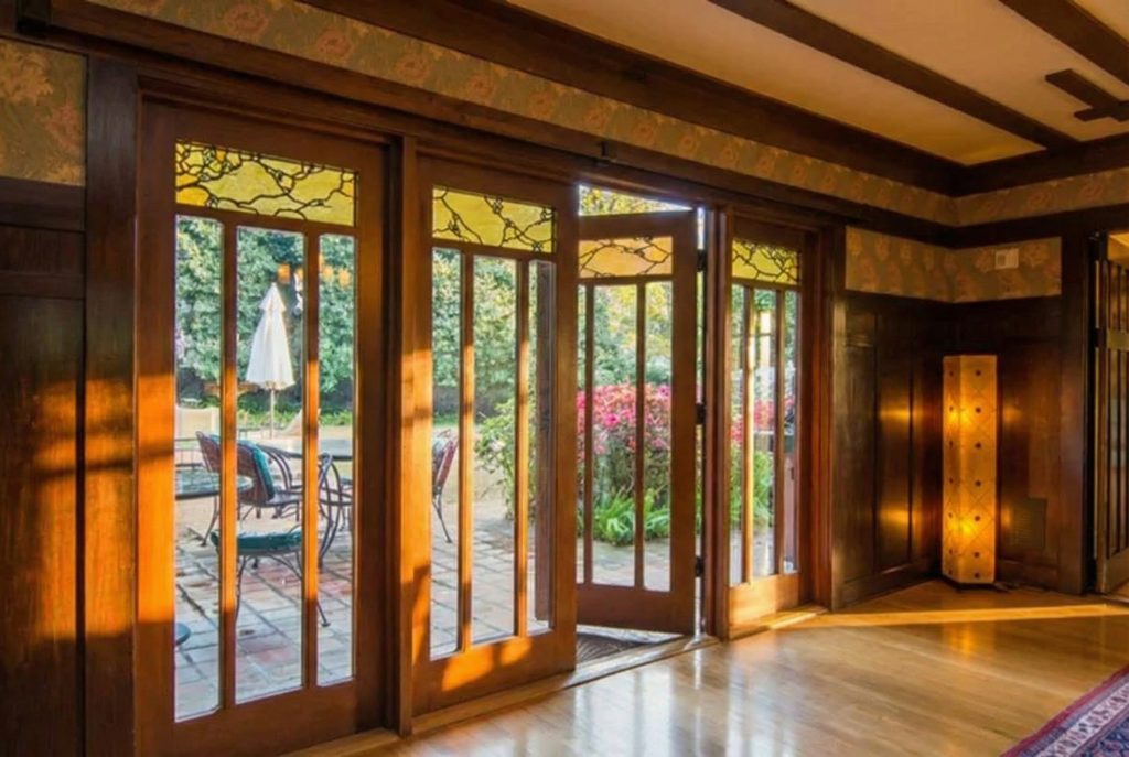 French doors opening to the rear terrace at The Earle C. Anthony house with original woodwork and leaded glass panels