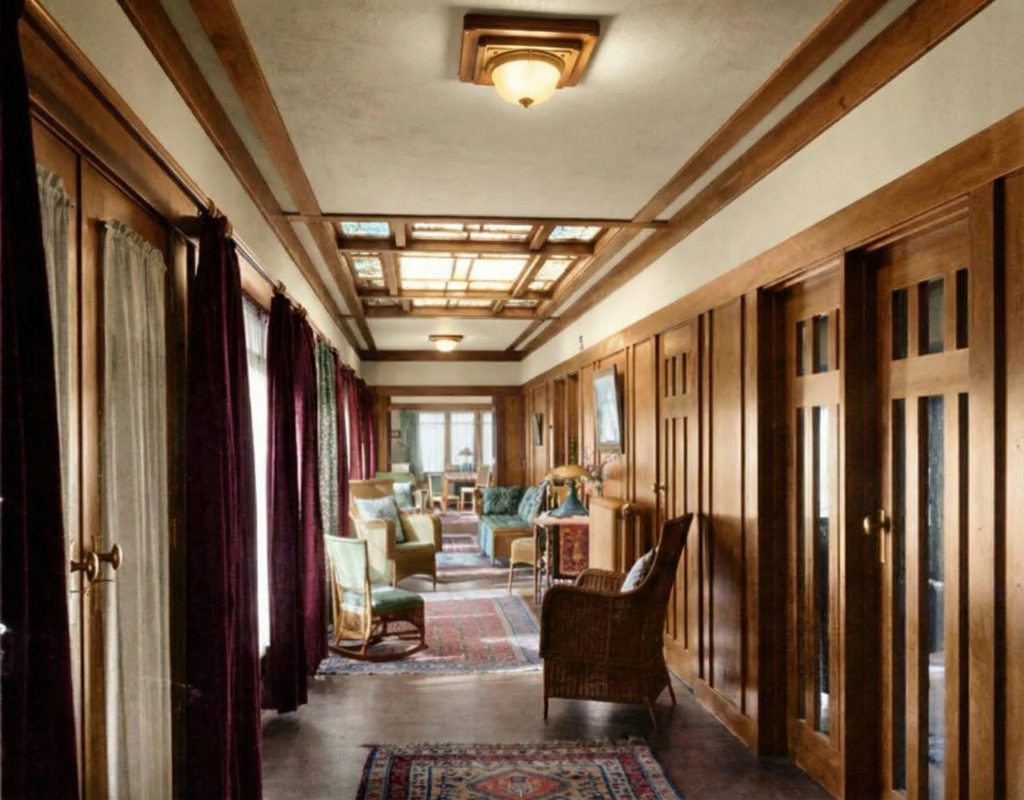 1915 photo by Leroy Hulbert of the sunroom in The Dr. S. S. Crow House, capturing the light-filled space with its large skylight and wicker furniture.