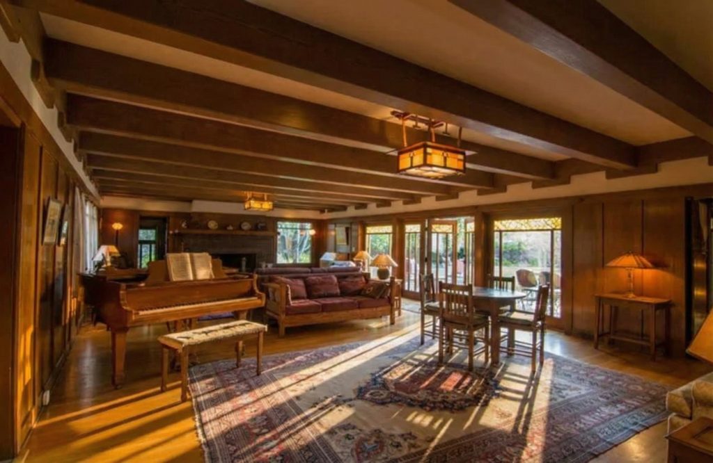 The Earle C. Anthony house living room showcasing exposed beam ceilings, wood-paneled walls, and period furnishings