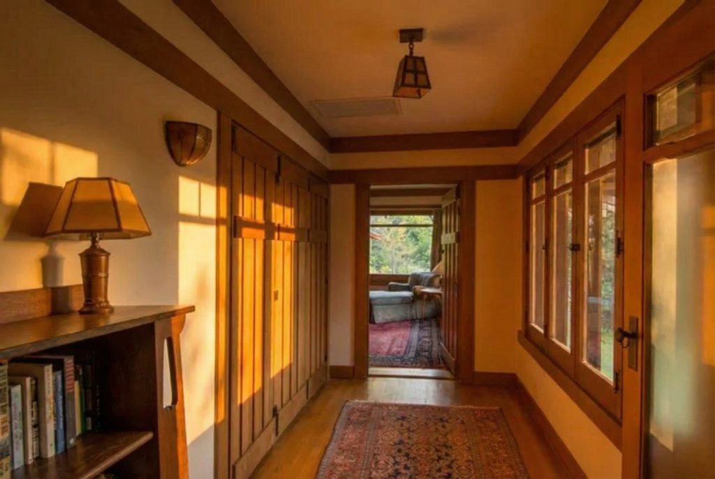 Second floor hallway of The Earle C. Anthony house with wood-paneled walls, exposed ceiling beams, and period details