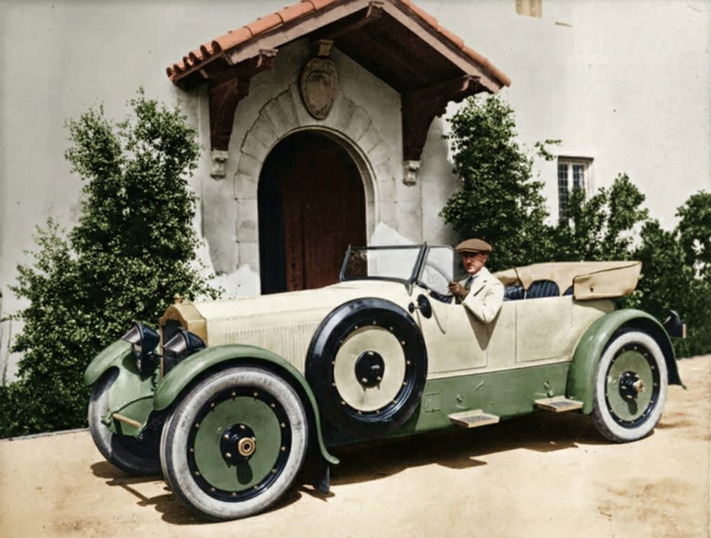 Tod Ford, Jr. with his automobile in front of The Tod Ford, Jr. House property on South Grand Avenue, Pasadena
