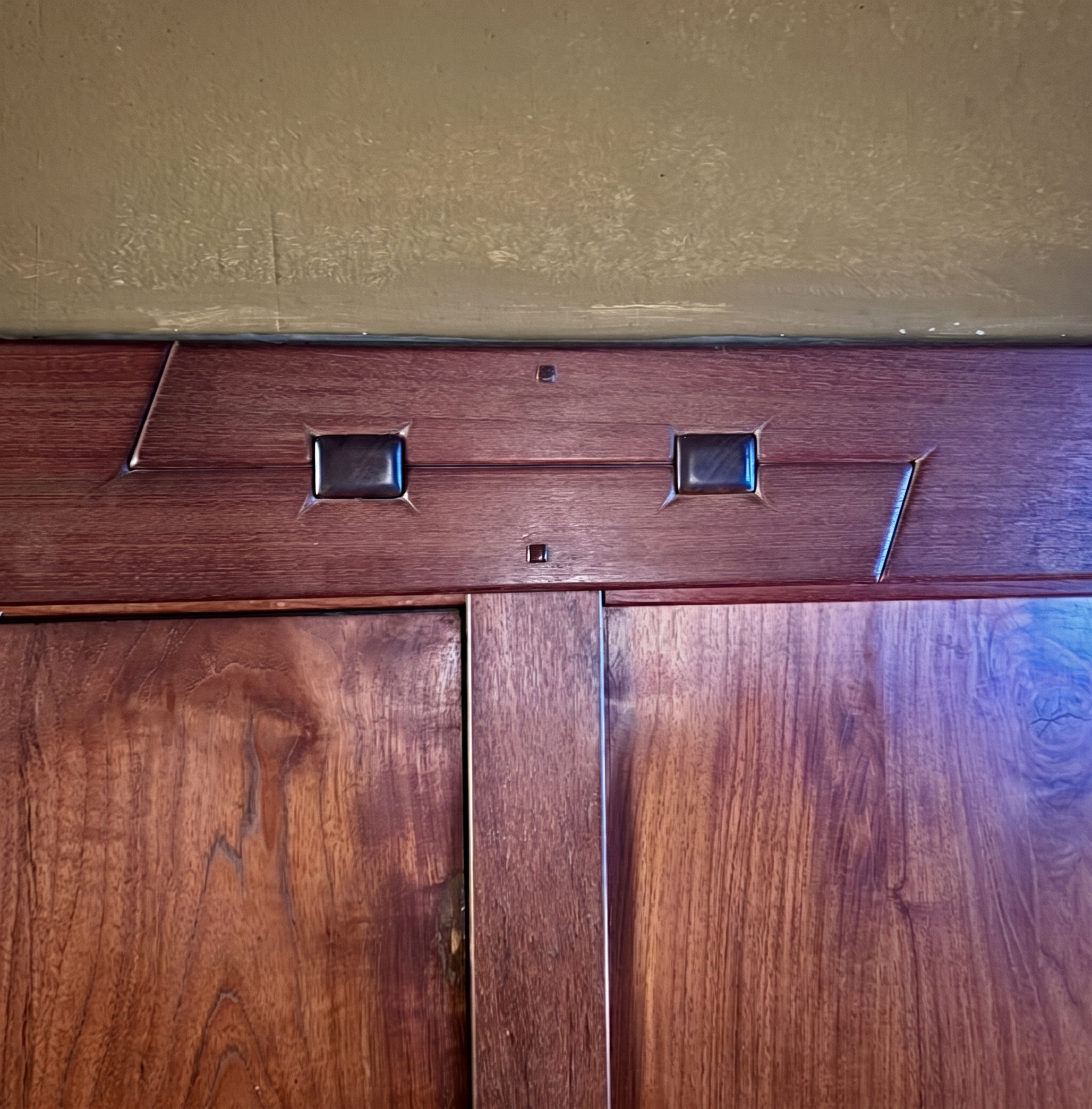Interior detail of an exposed scarf joint at the Gamble House, showing the joint's pegs and proud spline against the surrounding wood.