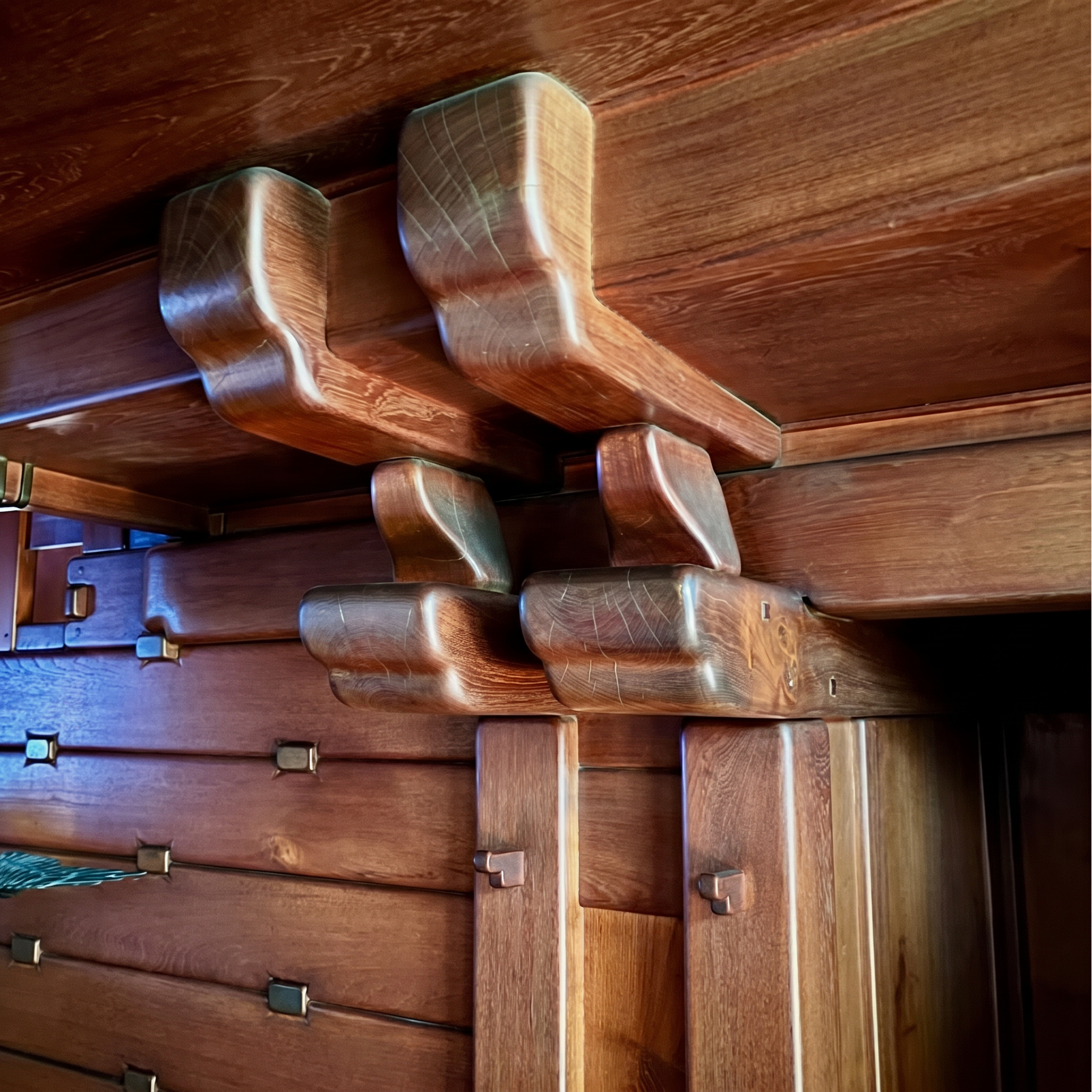 Interior view of the teak entrance hall at the David B. Gamble House showing the staircase with its pegged balustrade and exposed structural joinery.