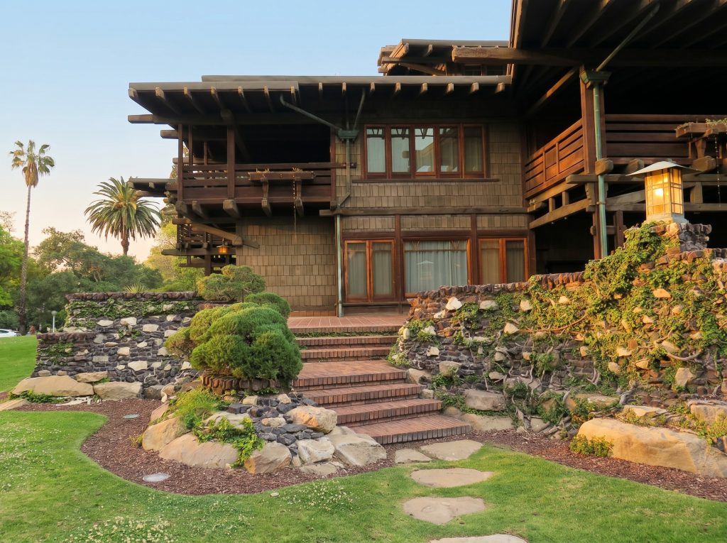 Northwest corner of the rear terrace at The David B. Gamble House in Pasadena California showing the integrated design featuring clinker brick and native arroyo stone.