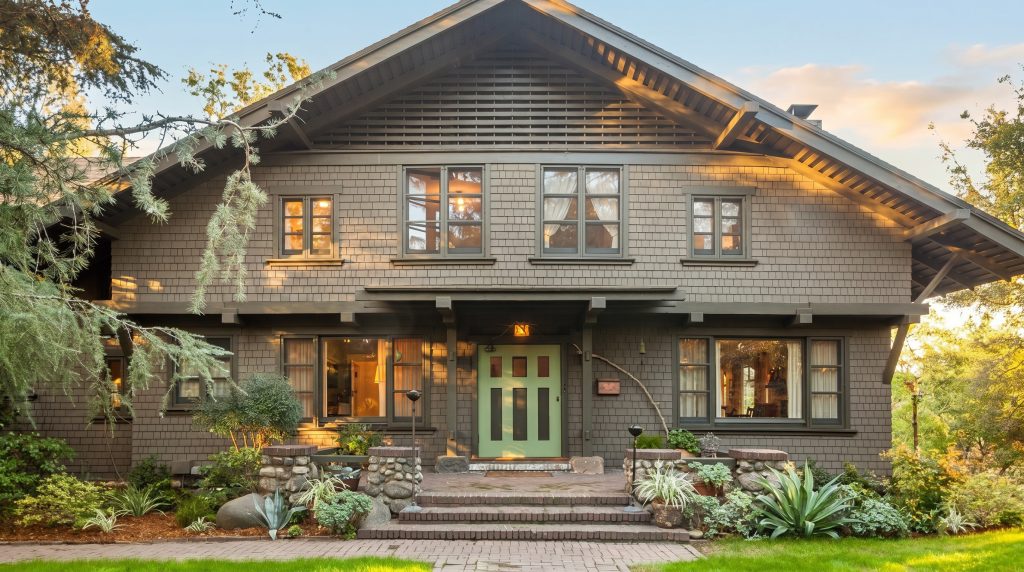 Contemporary front elevation of the Lucretia Garfield House with green Arts and Crafts door and agave plantings