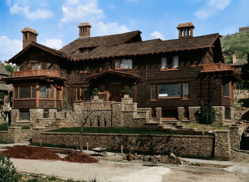Rendering of the Thorsen House at the corner of Piedmont Avenue, Berkeley, on its sloping urban site, seen from a distance with terraced clinker brick walls below the wood-shingled mass.