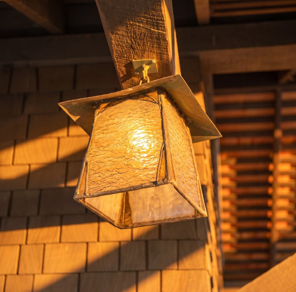 Custom Arts and Crafts hanging lantern at the Louise T. Halsted House entrance, with a wood and metal frame holding panels of softly iridescent glass