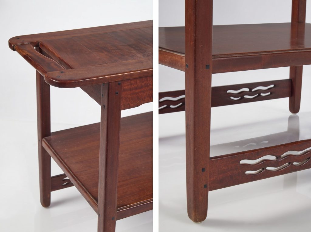 Two detail views of the Pratt House serving table: at left, the lifted corner of the top with its hand-rounded edge and square ebony pegs above the lower shelf; at right, a square leg meeting the pierced wave-pattern stretchers, joined with exposed ebony pegs.

